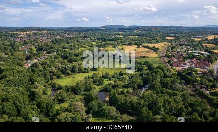Vista aerea del fiume Wey che serpeggia attraverso un vivace arazzo di foreste color smeraldo e prati assolati, Guildford, Surrey, Regno Unito. Foto Stock