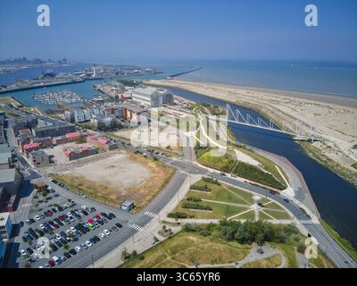 Vista aerea di una vivace scena costiera dove l'architettura moderna incontra il mare tranquillo vicino al porto di Dunkerque e alla spiaggia sabbiosa di Dunkerque, Francia. Foto Stock