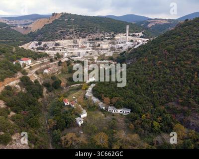 Vista aerea di un netto contrasto tra gli edifici industriali e le lussureggianti colline circostanti, Vavdos, Grecia. Foto Stock