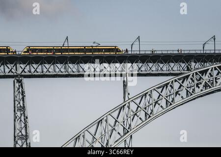 Porto, Portogallo - 17 giugno 2022: Veduta del ponte Dom Luís i, i suoi archi metallici che attraversano il cielo mentre sorvola un treno, una meraviglia dell'ingegneria e dei trasporti. Foto Stock