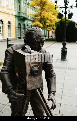 Statua in bronzo di un cameraman d'epoca - Ernest Bosnjak. La scultura rende omaggio al cinema e alla fotografia, in un'affascinante zona pedonale del Foto Stock