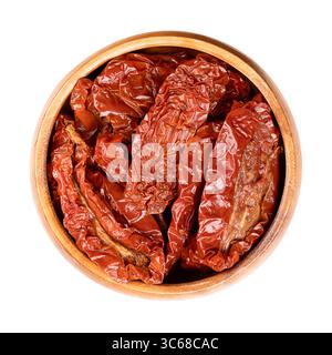 Pomodori secchi, antipasto in un recipiente di legno. Pomodori interi, essiccati all'aria sotto il sole italiano, trattati con sale marino per preservarli. Foto Stock