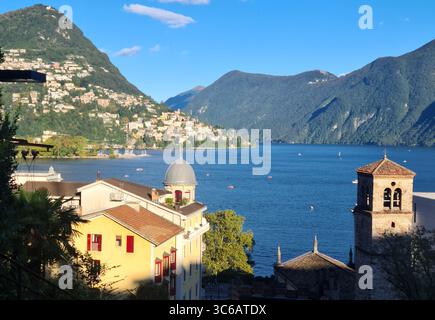 Lugano con il suo bellissimo lago offre viste mozzafiato con i suoi sontuosi palazzi, chiese, campanili, barche e padalos, i suoi negozi e parchi. Foto Stock