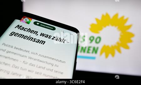 Stoccarda, Germania - 06-25-2025: Telefono cellulare con sito web del partito tedesco Buendnis 90 Die Gruenen (Verdi) sullo schermo davanti al logo. Foto Stock