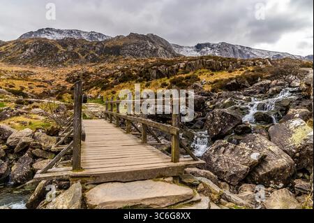 Una vista attraverso un ponte sul sentiero che porta al lago Idwal in Snowdonia, Galles in primavera Foto Stock