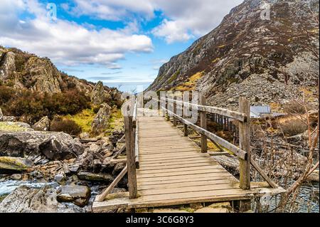 Una vista su un ponte che guarda lungo il sentiero che porta al lago Idwal in Snowdonia, Galles in primavera Foto Stock