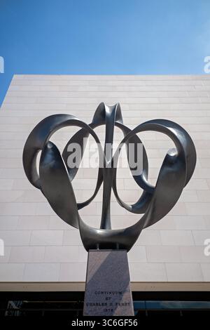 WASHINGTON DC - la scultura Continuum di Charles O. Perry è un'opera d'arte in bronzo alta 4 metri che esplora il concetto matematico della striscia di Möbius, posizionata all'ingresso di Independence Avenue del National Air and Space Museum. Perry ha progettato la scultura di 9.000 libbre con otto pezzi di bronzo separati montati su una base di granito, utilizzando un rivestimento in cera nera per creare un netto contrasto con l'esterno del museo. La scultura è stata commissionata appositamente per l'apertura bicentenaria del museo il 1 luglio 1976, quando il presidente Gerald Ford presiedette le cerimonie che includevano un taglio del nastro Foto Stock