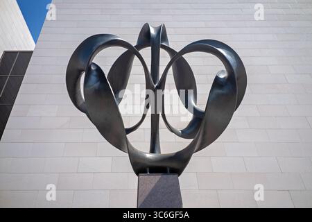 WASHINGTON DC - la scultura Continuum di Charles O. Perry è un'opera d'arte in bronzo alta 4 metri che esplora il concetto matematico della striscia di Möbius, posizionata all'ingresso di Independence Avenue del National Air and Space Museum. Perry ha progettato la scultura di 9.000 libbre con otto pezzi di bronzo separati montati su una base di granito, utilizzando un rivestimento in cera nera per creare un netto contrasto con l'esterno del museo. La scultura è stata commissionata appositamente per l'apertura bicentenaria del museo il 1 luglio 1976, quando il presidente Gerald Ford presiedette le cerimonie che includevano un taglio del nastro Foto Stock