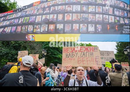 Kiev, Ucraina - 31 luglio 2025: Cittadini ucraini che protestano per l'indipendenza di NABU e SAPO, tenendo in mano cartelli e mostrando ritratti di soldati caduti su uno striscione sullo sfondo. Contex ( il 22 luglio, la Verkhovna Rada votò per una legge che scatenò proteste in Ucraina. L'iniziativa prevedeva che i due principali organismi anticorruzione (NAB e SAPO) sarebbero stati trasferiti sotto il controllo del procuratore generale. Dopo numerose proteste e pressioni pubbliche, la Verkhovna Rada votò per garantire l'indipendenza di questi organismi ) Foto Stock