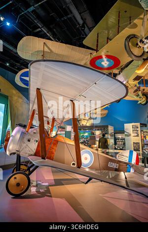 Sopwith F.1 Camel Fighter Aircraft presso lo Smithsonian National Air and Space Museum di Washington DC | WASHINGTON D.C., Stati Uniti — Una vista ravvicinata del Sopwith F.1 Camel B6291 presso lo Smithsonian National Air and Space Museum mostra l'elica in legno del caccia, il cofano motore rotativo e le navicelle della Royal Air Force sotto un hangar di biplani dell'era della prima guerra mondiale. Il Camel entrò in servizio britannico nel 1917 e superò ogni altro combattente alleato in combattimento aereo durante la guerra. Foto Stock