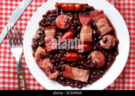Piatto tradizionale brasiliano Feijoada servito con riso, farofa e Kale. Cibo tipico. Vista dall'alto Foto Stock