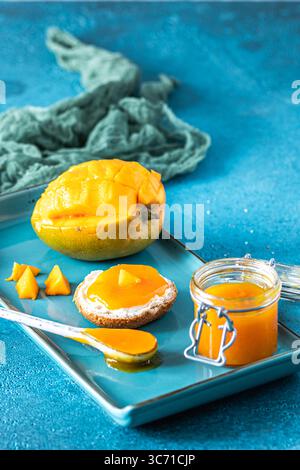 Chuntney di mango fatti in casa e ingredienti su sfondo blu, verticale Foto Stock