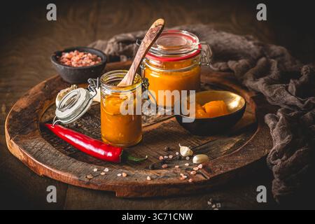 Chuntney di mango fatti in casa e ingredienti su sfondo di legno scuro Foto Stock
