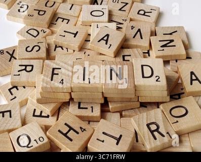 Primo piano di tessere di legno vintage Scrabble che mostrano lettere diverse. La parola TROVA è nascosta tra le lettere. Foto scattata Ontario Canada luglio 30, Foto Stock