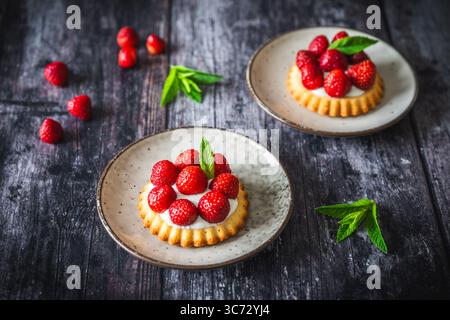 Tartine di fragole fatte in casa su un rustico tavolo di legno scuro Foto Stock