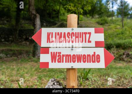 Germania - 30 luglio 2025: FOTOMONTAGGIO, cartello con la protezione del clima e la transizione termica - l'immagine simboleggia la necessità politica di trasformare i sistemi di riscaldamento e la tecnologia degli edifici in modo rispettoso del clima. *** FOTOMONTAGE, Wegweiser mit Klimaschutz und Wärmewende das Bild steht symbolisch für die politische Notwendigkeit, Heizsysteme und Gebäudetechnik klimafreundlich zu transformieren. Foto Stock