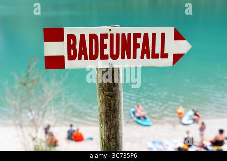 Germania - 30 luglio 2025: IL FOTOMONTAGGIO, Un cartello con un incidente in bagno, ricorda i rischi in acqua - un simbolo serio dell'importanza dell'attenzione, della supervisione e del salvataggio delle acque nei luoghi di balneazione. *** FOTOMONTAGE, Ein Schild mit Badeunfall erinnert an die Risiken am Wasser ein ernstes Symbol für die Wichtigkeit von Achtsamkeit, Aufsicht und Wasserrettung an Badestellen. Foto Stock