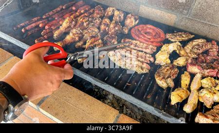 Pezzi di carne e salsicce su un barbecue Foto Stock