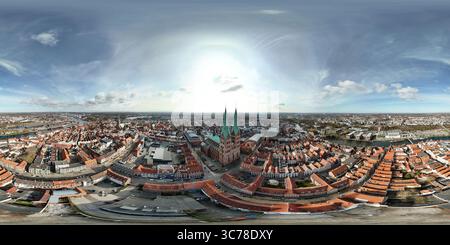 Vista panoramica aerea di una storica città europea di Lubecca, in Germania, con una cattedrale di primo piano, circondata da edifici dal tetto rosso e da un fiume nel Foto Stock