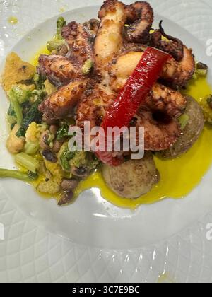 Polpo tradizionale portoghese "Polvo à Lagareiro" servito con patate, verdure e olio d'oliva. Foto Stock