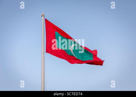 Bandiera nazionale della Repubblica delle Maldive con un rettangolo verde centrato su un campo rosso e una mezzaluna bianca rivolta verso il lato della mosca, che vola al vento Foto Stock