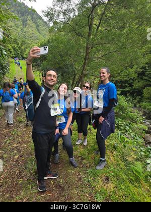 I partecipanti che corrono e camminano attraverso i lussureggianti sentieri della foresta e le strade storiche della città durante l'evento Trail Real Priolo nell'isola di São Miguel, nelle Azzorre, Foto Stock