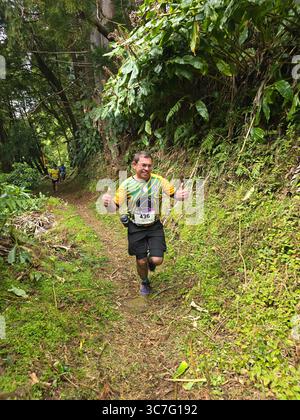 I partecipanti che corrono e camminano attraverso i lussureggianti sentieri della foresta e le strade storiche della città durante l'evento Trail Real Priolo nell'isola di São Miguel, nelle Azzorre, Foto Stock