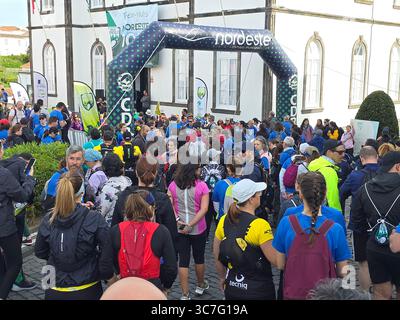 I partecipanti che corrono e camminano attraverso i lussureggianti sentieri della foresta e le strade storiche della città durante l'evento Trail Real Priolo nell'isola di São Miguel, nelle Azzorre, Foto Stock