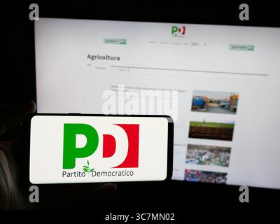 In questa foto, una persona ha in mano uno smartphone con il logo del Partito Democratico (PD) sullo schermo davanti al sito web. Foto Stock