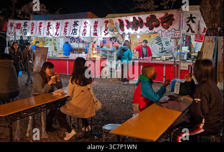 Sakura Matsuri (festival della fioritura dei ciliegi) stand gastronomici che vendono ikayaki, okonomiyaki, yakitori, karaage, ramen e altri spuntini notturni, Hikone, Giappone. Foto Stock