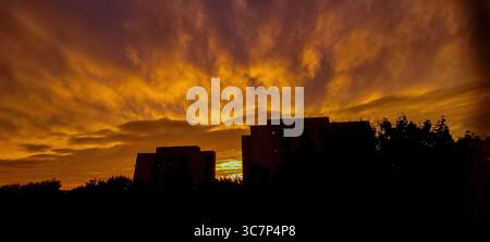 Un tramonto mozzafiato si dispiega su un incantevole paesaggio urbano pieno di bellezza Foto Stock