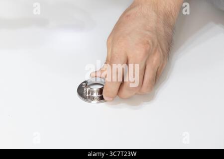 Primo piano delle mani che montano un anello metallico per appendiabiti durante l'assemblaggio del guardaroba, concetto di fai da te e installazione di mobili per la casa Foto Stock