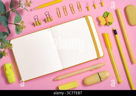 Pagina vuota per il testo nella cornice della cancelleria gialla per la scuola e l'ufficio su sfondo rosa. Gomma sotto forma di farfalla Foto Stock