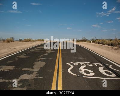Simbolo sbiadito della strada Route 66 dipinto su asfalto incrinato nel deserto dell'Arizona, Stati Uniti. Foto scattata nell'agosto 2007. Foto Stock
