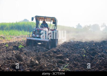 Il trattore ara il campo agricolo. Trattamento del campo con un trattore. Il trattore sta elaborando il campo. Industria agricola, coltivazione della terra. Foto Stock