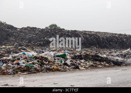 Pile di rifiuti domestici sono lasciate sul lato della strada. Lo scarico dei rifiuti in questo modo è inquinante per l'ambiente. Foto Stock