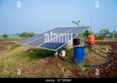 I pannelli ad energia solare sono installati in terreni agricoli, campi o aziende agricole. File di pannelli solari a energia sostenibile installati su terreni agricoli prati campi rurali Foto Stock