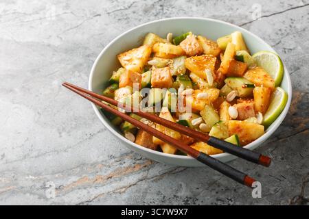 Insalata di frutta e verdura rojak asiatica con formaggio tofu condita con salsa dolce e piccante da vicino in una ciotola sul tavolo. Orizzontale Foto Stock