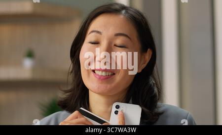 Donna asiatica donna donna acquirente acquirente di shopping felice consumatore donna cinese coreano giapponese donna d'affari soddisfatto donna d'affari acquistare online in Foto Stock