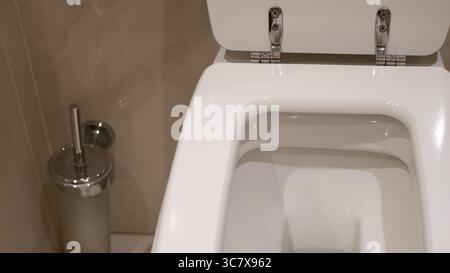Moderno WC bianco con coperchio aperto in bagno Foto Stock