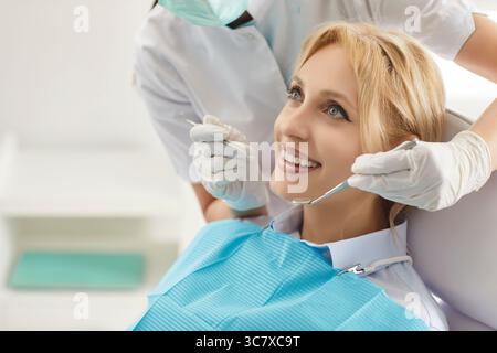 Una donna felice che visita la clinica odontoiatrica, è venuta su appuntamento dal dentista per un controllo regolare dei denti Foto Stock