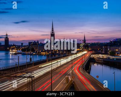 Stoccolma, Svezia - 5 giugno 2025: Una splendida vista crepuscolare di Stoccolma, che mostra lo skyline della città con l'architettura storica, un ponte illuminato Foto Stock