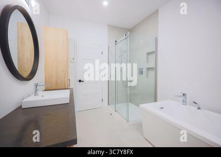 Un bagno pulito e ben illuminato in una casa, caratterizzato da arredi moderni e un design minimalista. Foto Stock