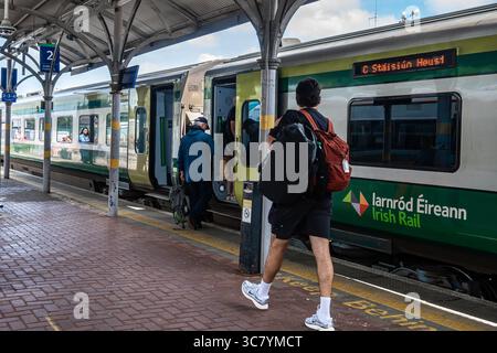 25 luglio 2025 Cork, Irlanda Un passeggero si imbarcherà su un treno presso una stazione ferroviaria irlandese, godendosi il viaggio in avanti Foto Stock
