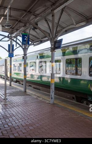 25 luglio 2025 Cork, Irlanda Modern Train Station Platform accoglie l'arrivo di un elegante treno per passeggeri Foto Stock