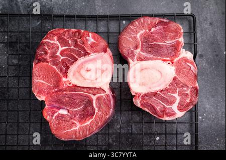 Ossobuco crudo fresco codolo di vitello Premium, ideale per cucinare lentamente e creare pasti sostanziosi e confortanti che impressionano. sfondo nero. vista dall'alto. Foto Stock
