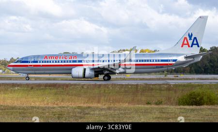 Un Boeing 737 di American Airlines su una pista, pronto per il decollo, sotto un cielo parzialmente nuvoloso. L'aereo presenta la classica American Airline Foto Stock