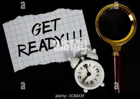 Testo pronto scritto su carta con lente d'ingrandimento e sveglia Foto Stock