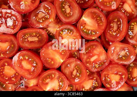 Primi piani con cerchi di pomodoro a fette. Verdure culinarie fresche di sottofondo Foto Stock