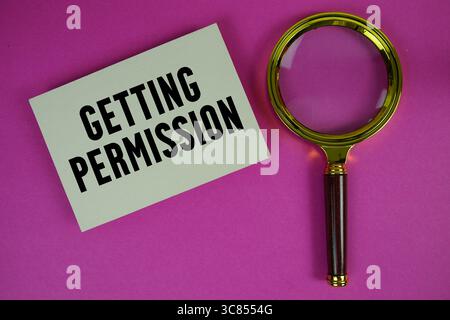 Ottenimento del testo di autorizzazione scritto su carta con lente d'ingrandimento Foto Stock